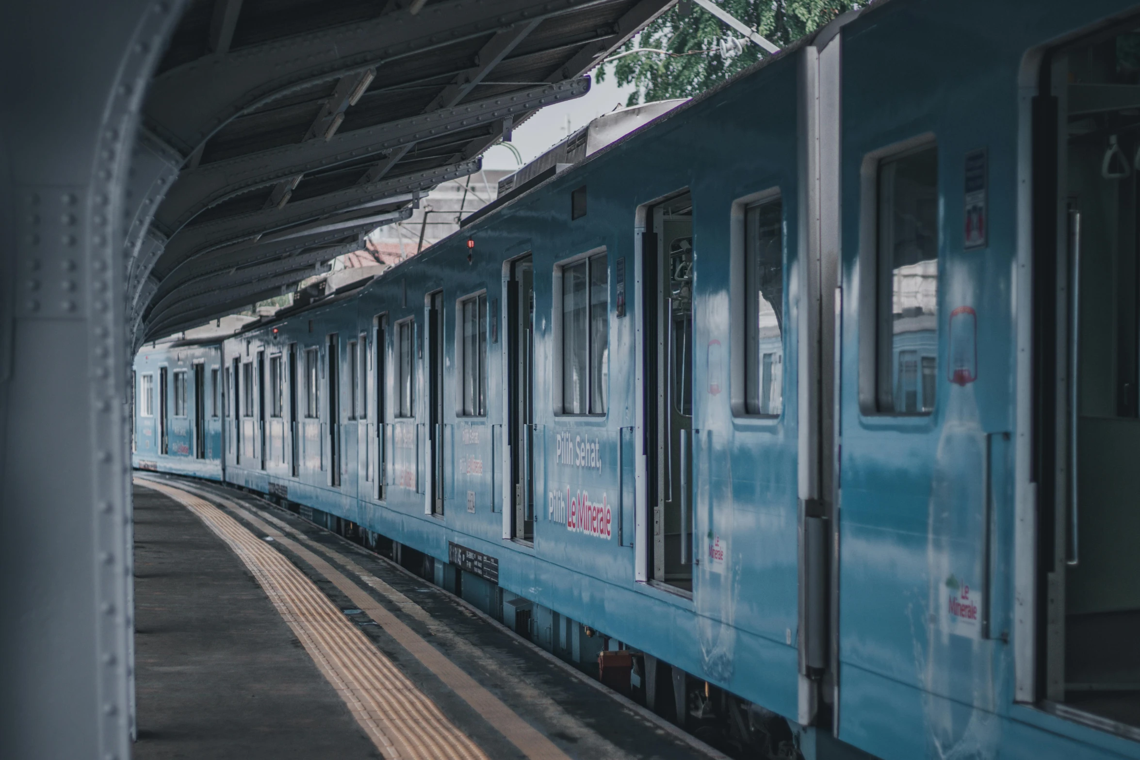 a blue train is traveling down the tracks