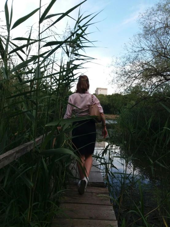 a woman walking along a dock on a river
