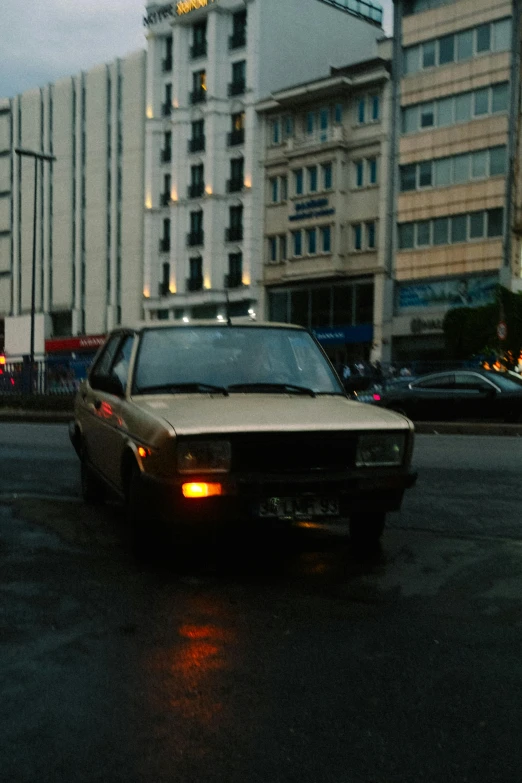 car parked next to tall buildings and an apartment building