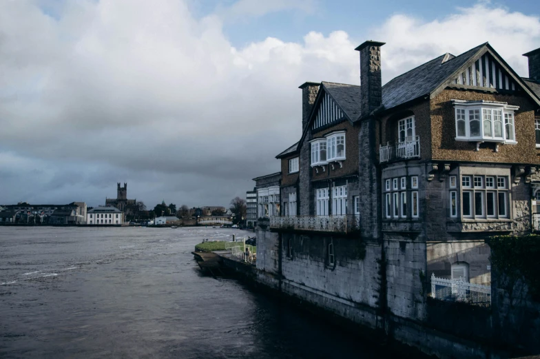 an old building on a side walk along the water