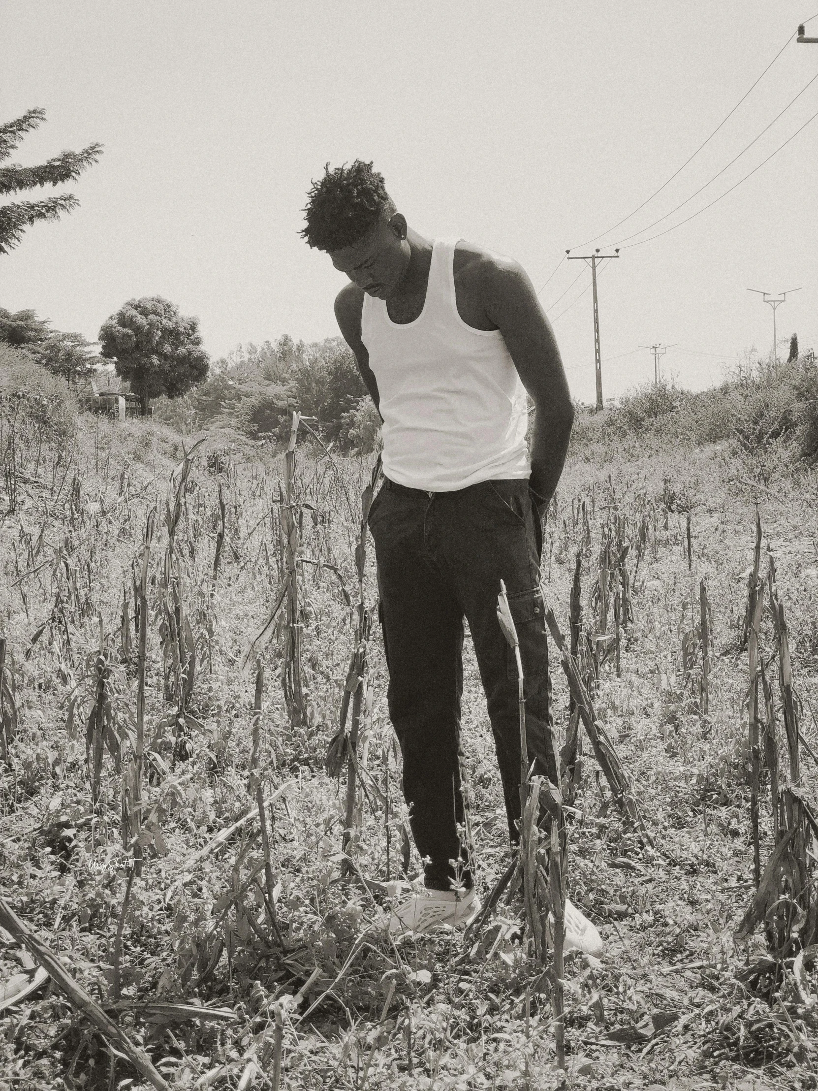 a man standing in the middle of the field, in a black and white po