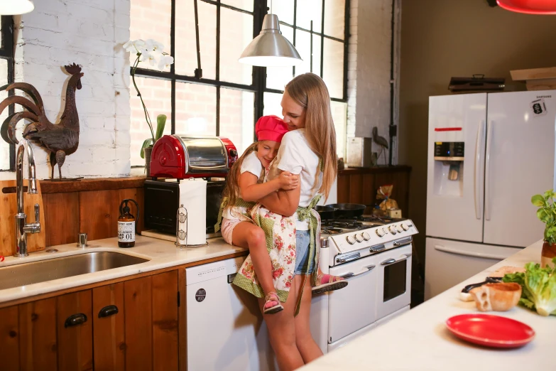 a  holding a little  who is sitting on a kitchen counter