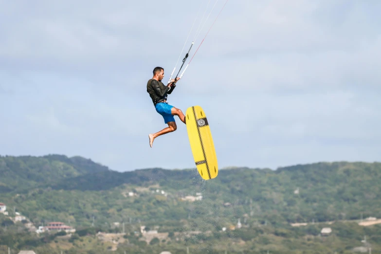 a man on the beach water jumping with a board attached to his handle