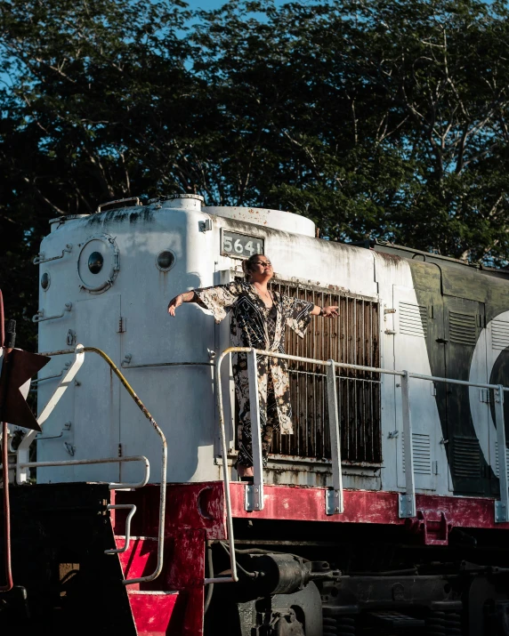 the man is standing on the balcony of the train