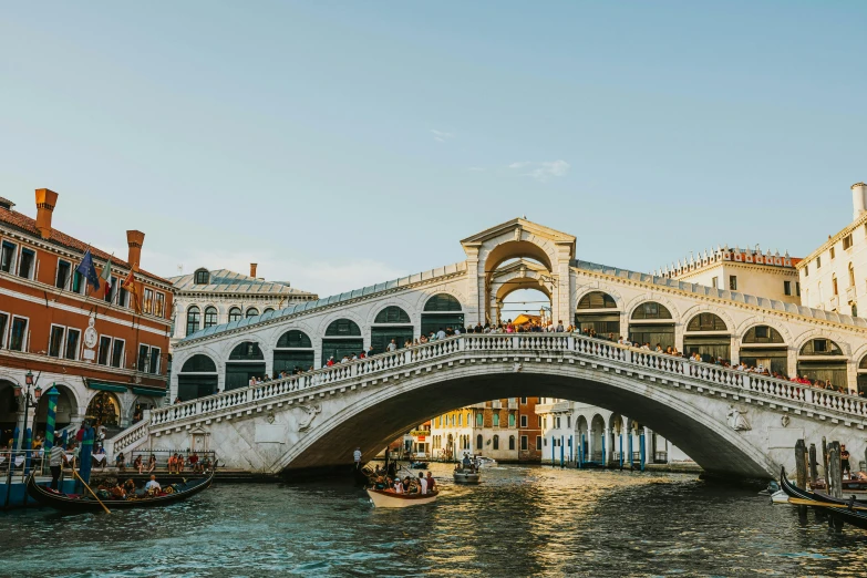 a bridge spanning across the water with people on boats