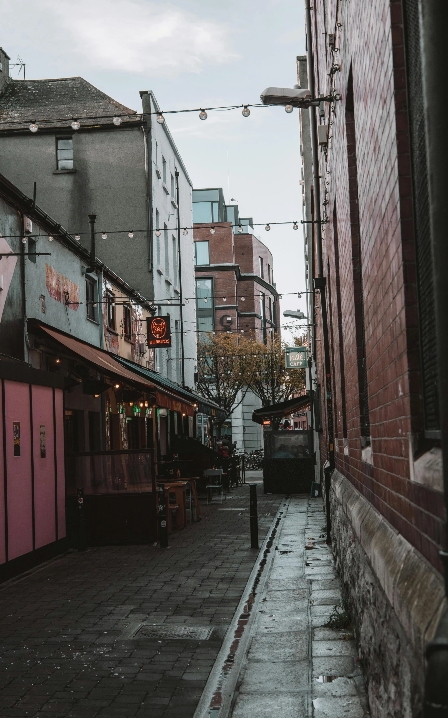 street view of street with red brick buildings and outdoor cafe