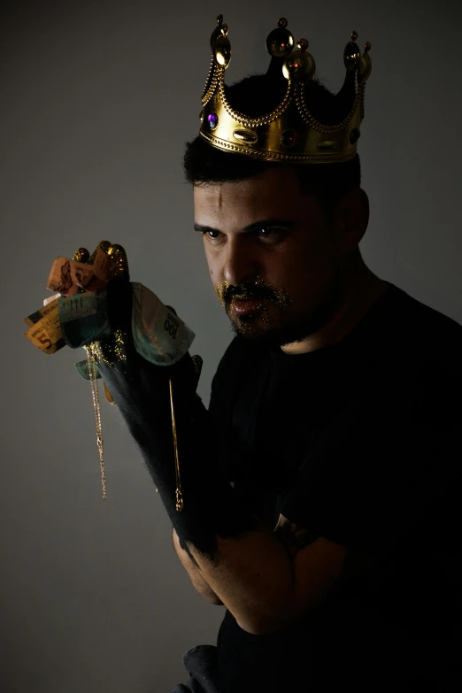 a man with a gold crown holding a fish