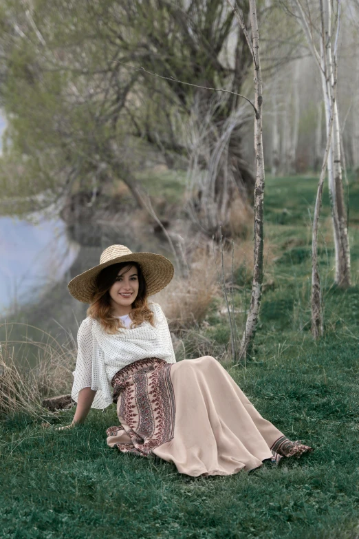 a girl with a hat sitting on the ground