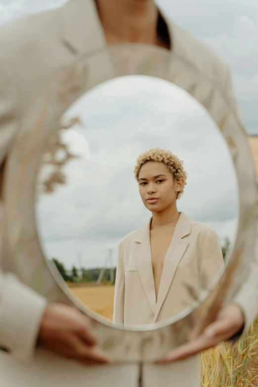 a woman in a business suit holding a mirror