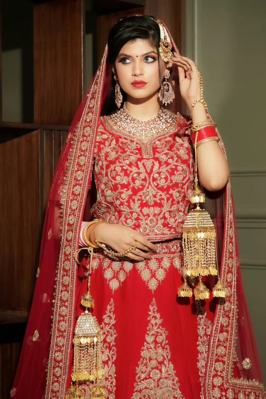 a woman in an oriental wedding outfit with jewelry on her hand