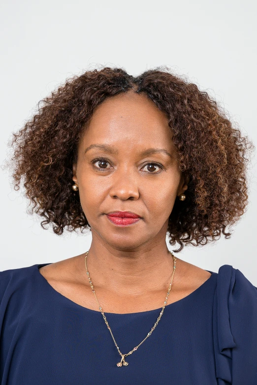 a woman with a necklace on in a blue shirt