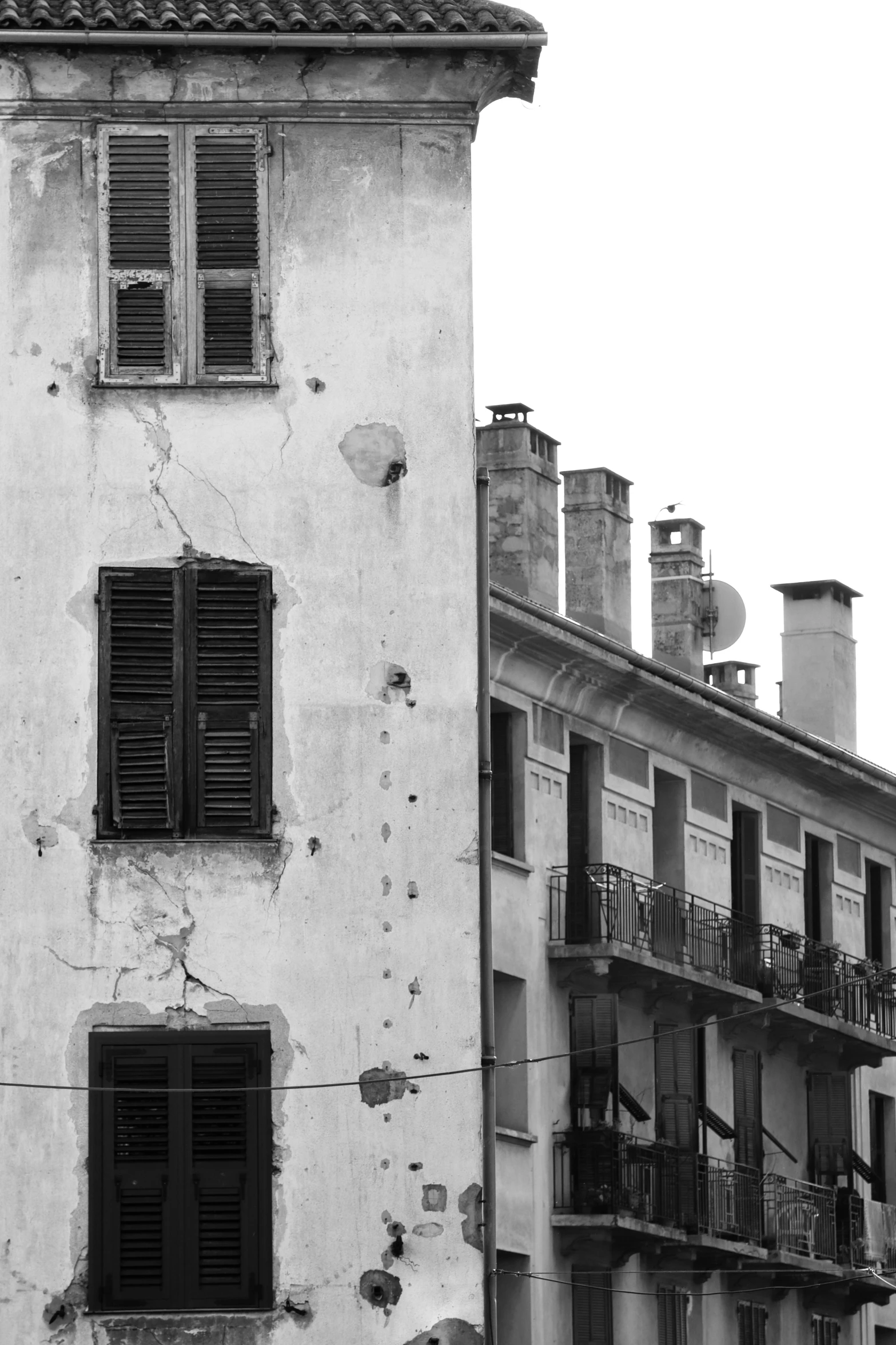 a dilapidated building with several windows and balconies