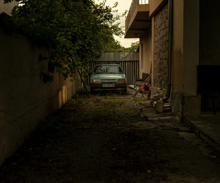 an old truck sits in a alley between some buildings