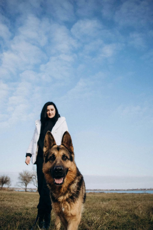 a girl is standing with a dog in front of her