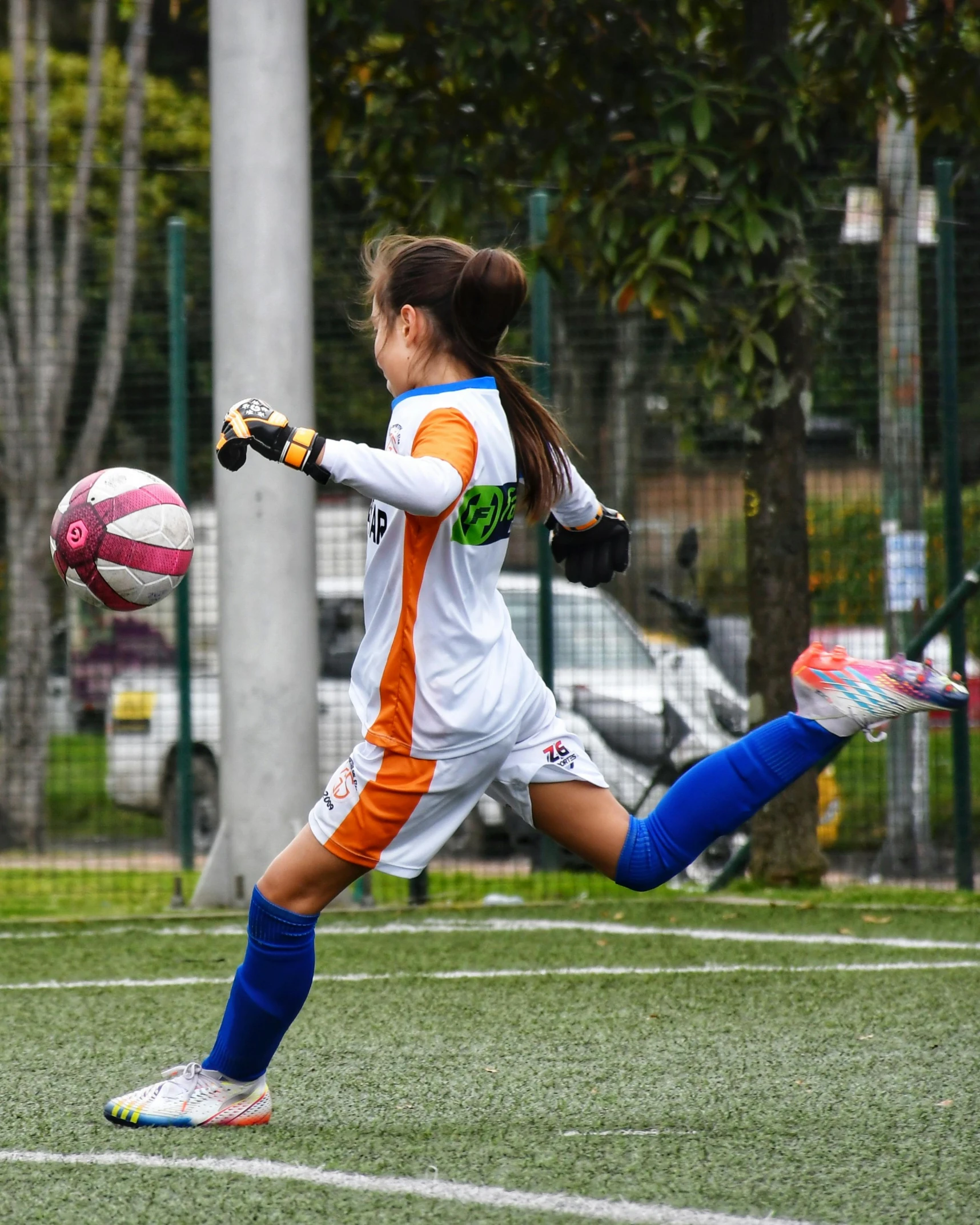 there is a girl that is kicking a soccer ball