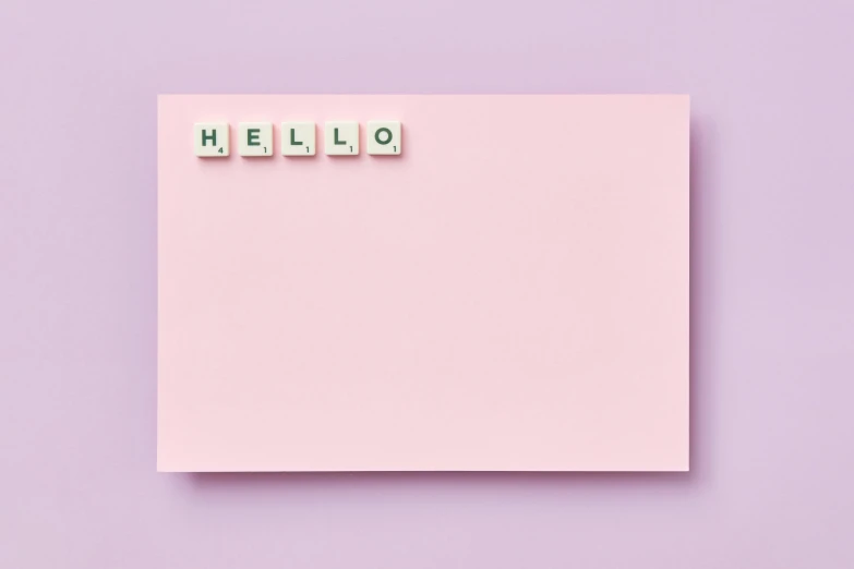 hello spelled in small letter blocks on a pink sticky note