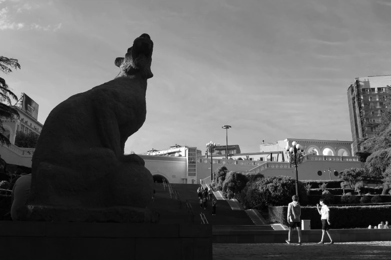 two statues of people are shown near some buildings