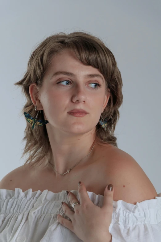 a woman with a white top wearing large earrings