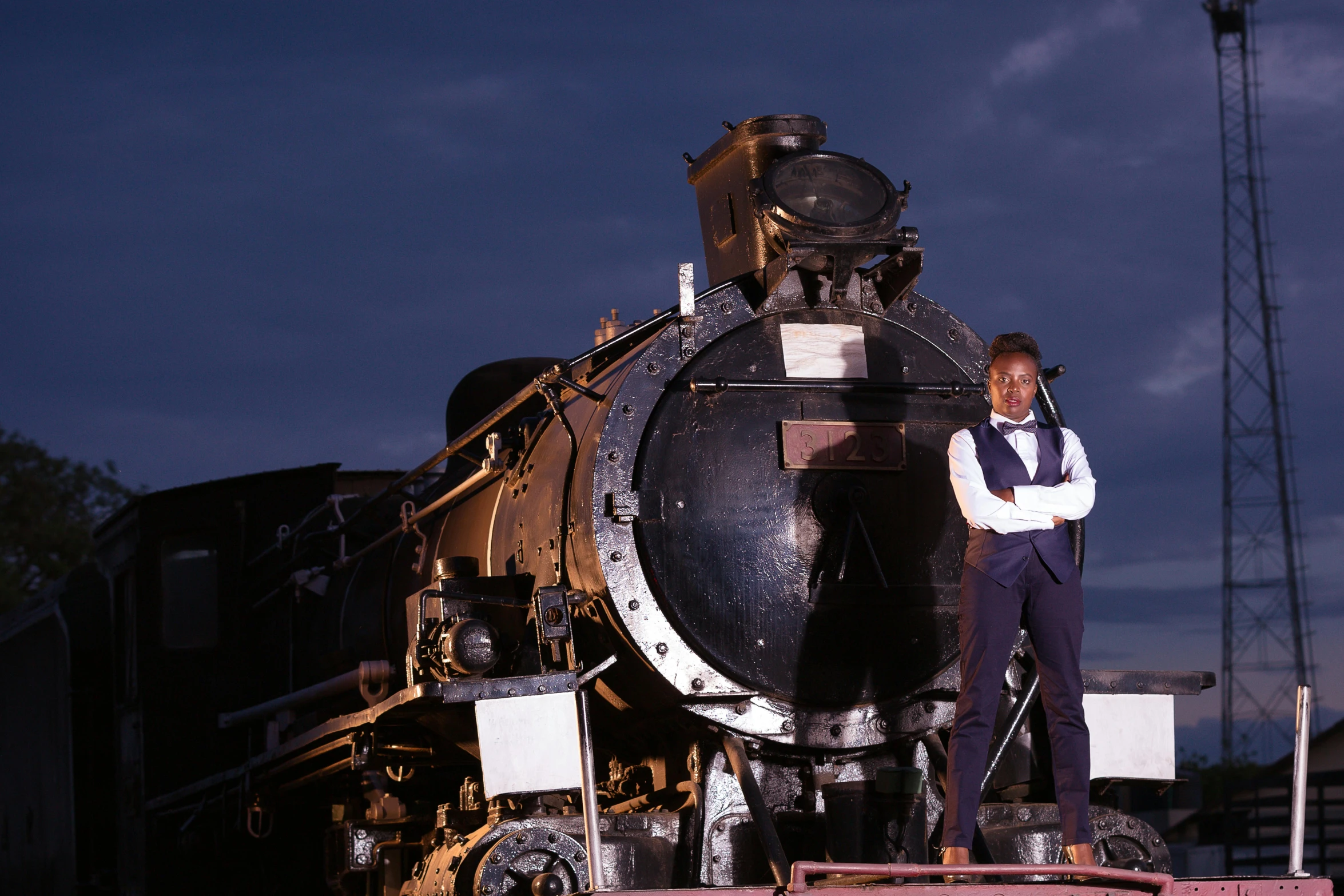 a female train engineer is posing on top of a train