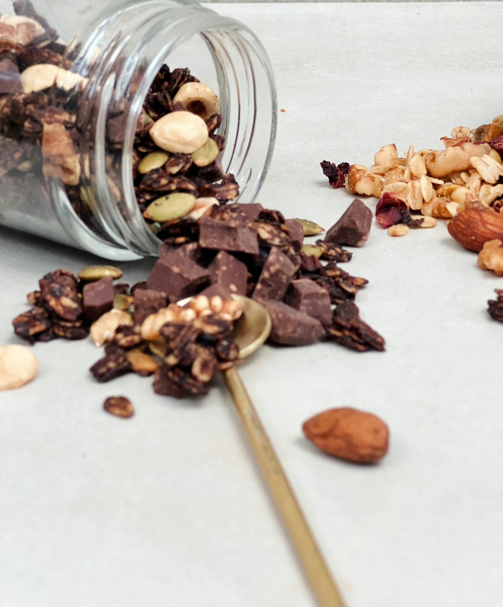 some mixed nuts scattered over the counter near a jar