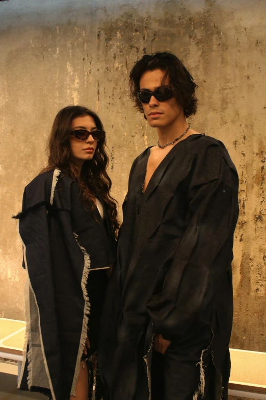 two people dressed up in black clothes standing