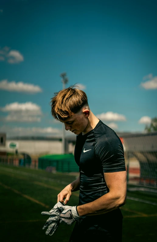 a man is looking down at his gloves