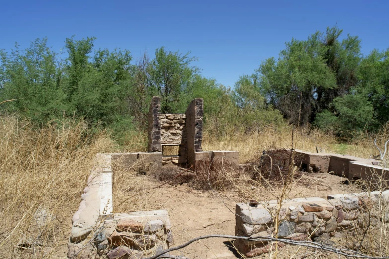 an empty brick structure surrounded by a field