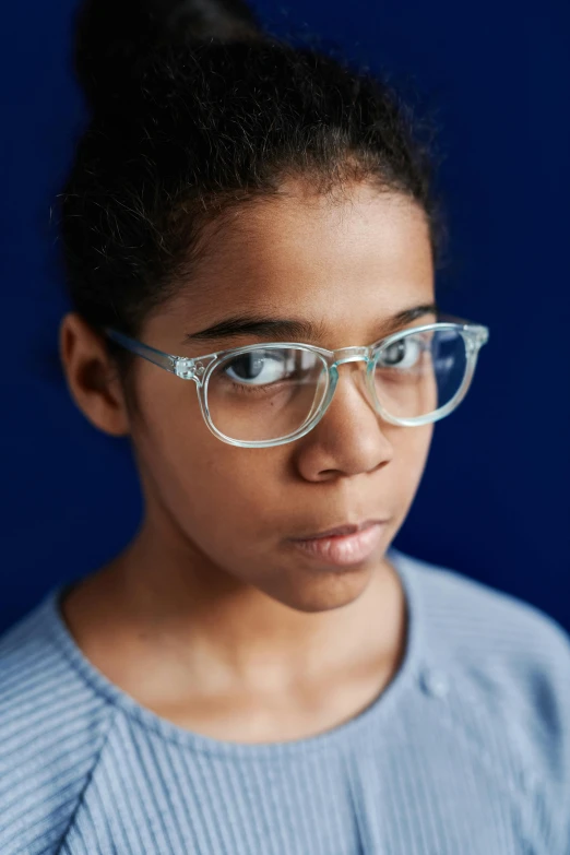 a woman wearing glasses looking off to the side