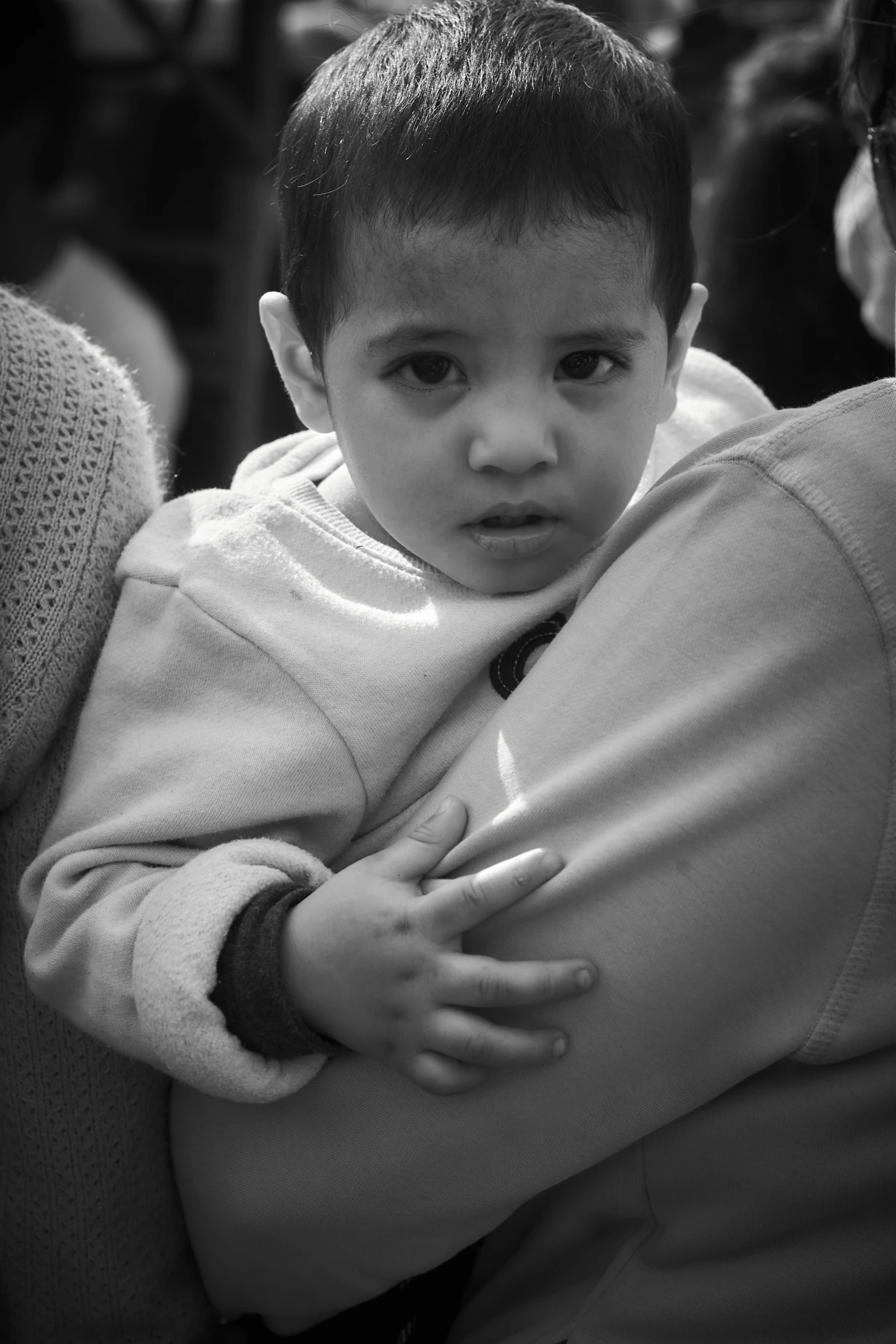 a young child holding a woman in a crowded place