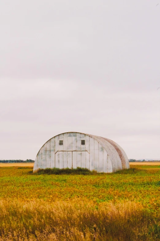 a barn is sitting alone on the side of the road