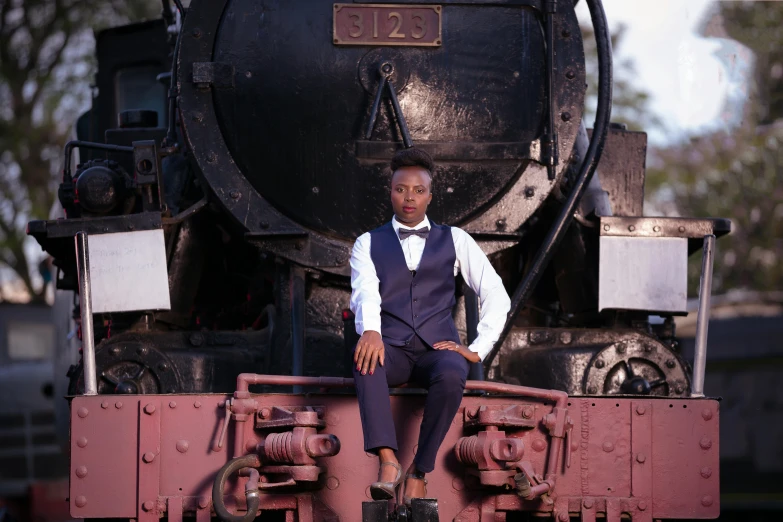 a man sitting on a train that has an engine behind him