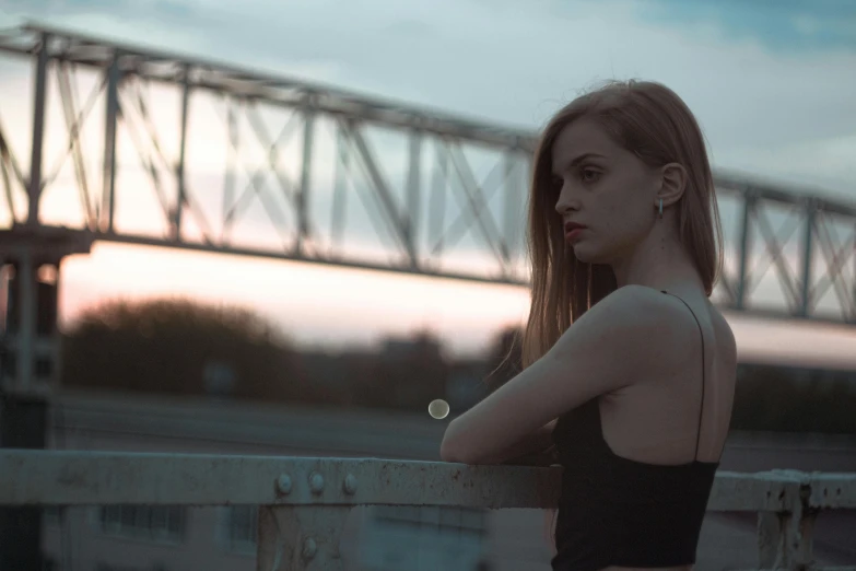 a young woman is standing behind a fence