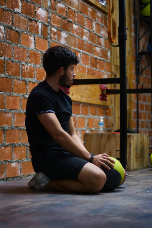 a man sitting on the floor with a ball in his hand