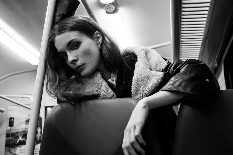 black and white pograph of woman leaning against the wall