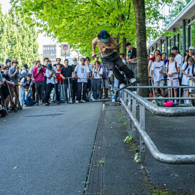 a man is skateboarding on the rails near a group of people