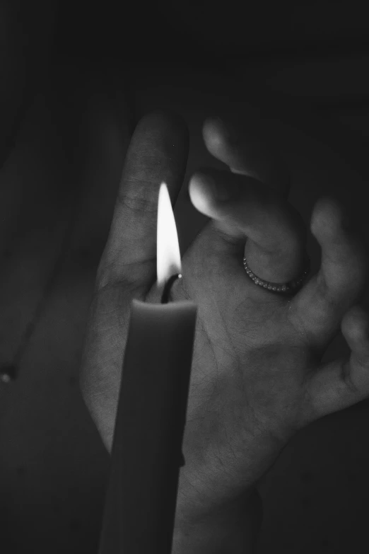 a close up of a person holding a lit candle