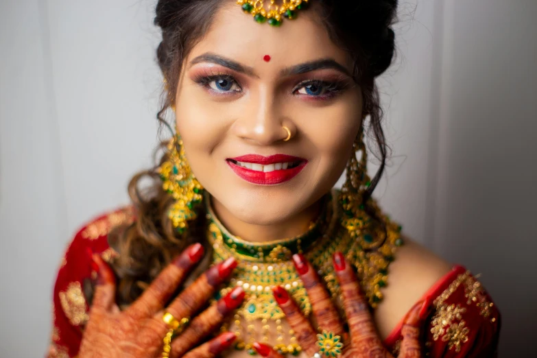 a close - up of the face and neck of a woman dressed in indian costume, showing off her elaborate jewellery and make up