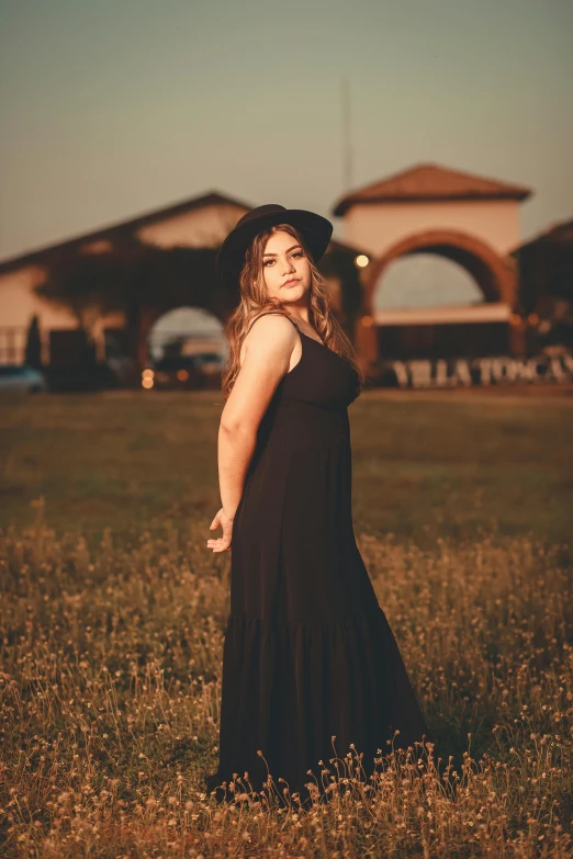 a woman standing in the grass next to a building