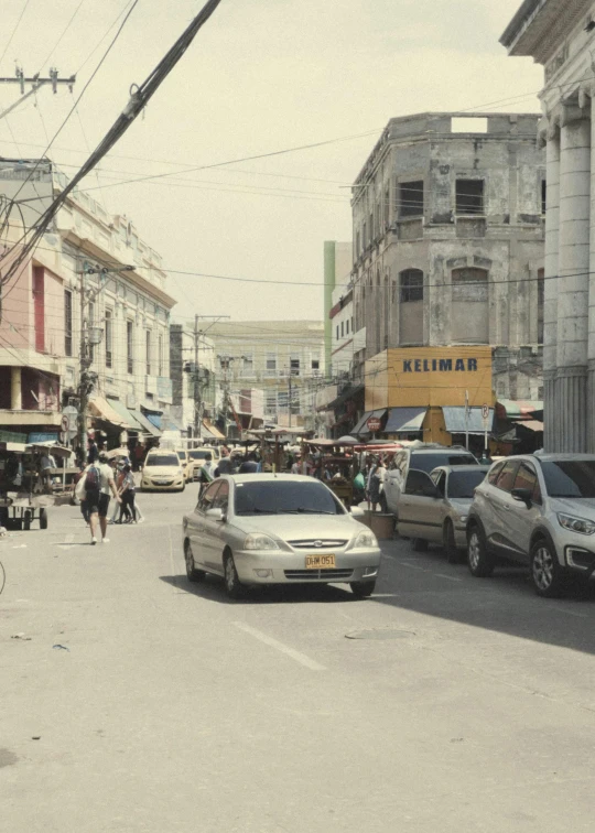 cars parked on a city street with a few people on a bicycle