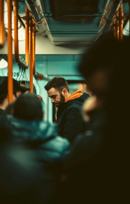 a man on a subway while looking down at his cell phone