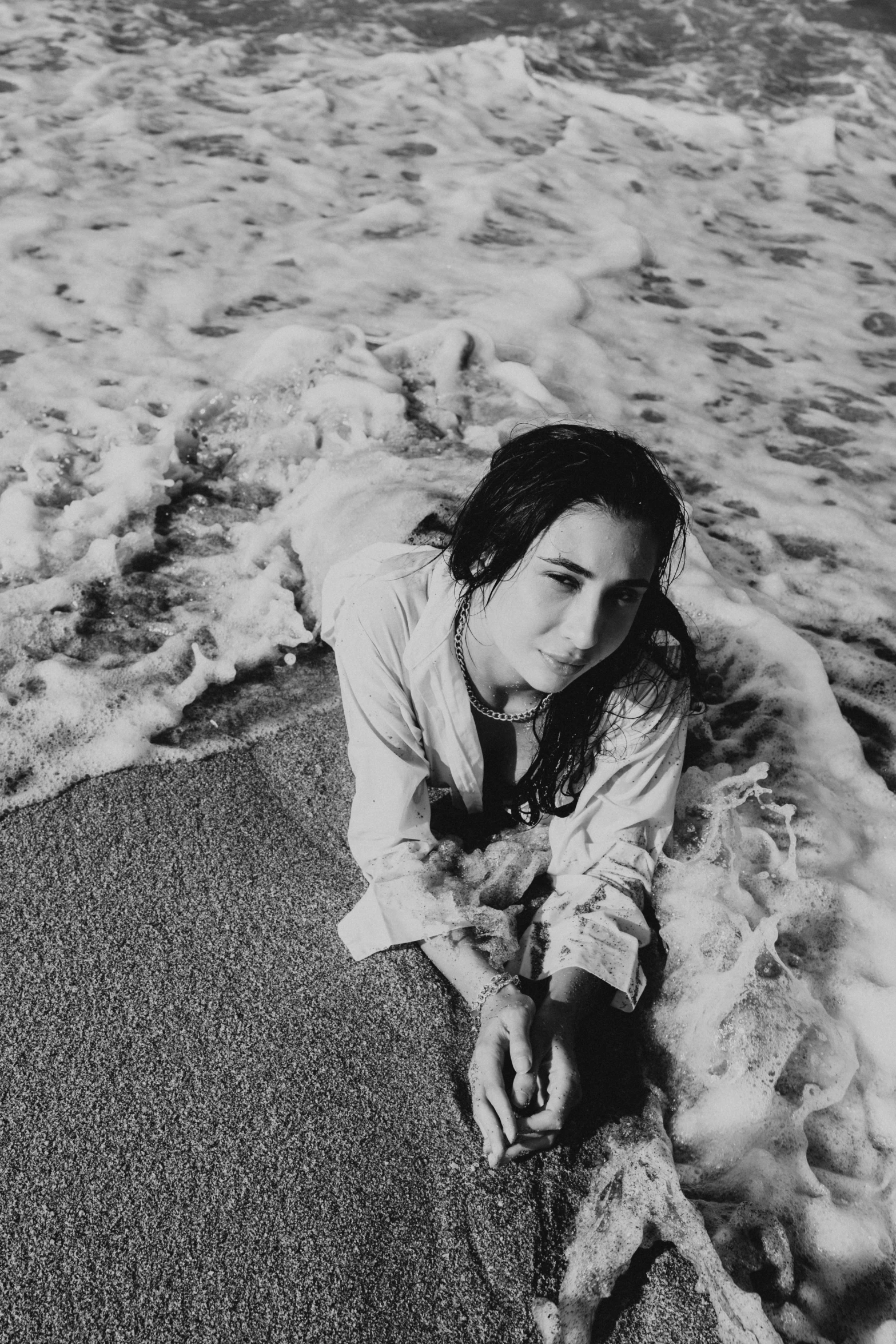 a woman laying on the beach next to a ocean