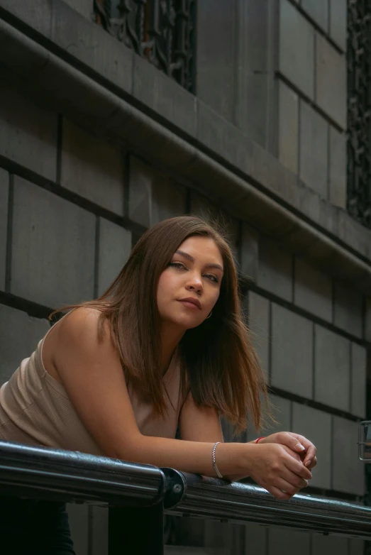 a beautiful young woman leaning on a ledge and looking into the distance