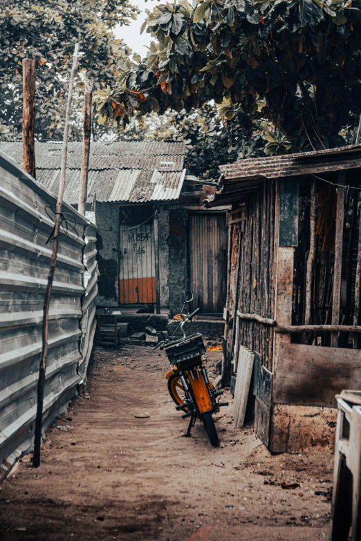 a bike parked in a dirt lot next to buildings