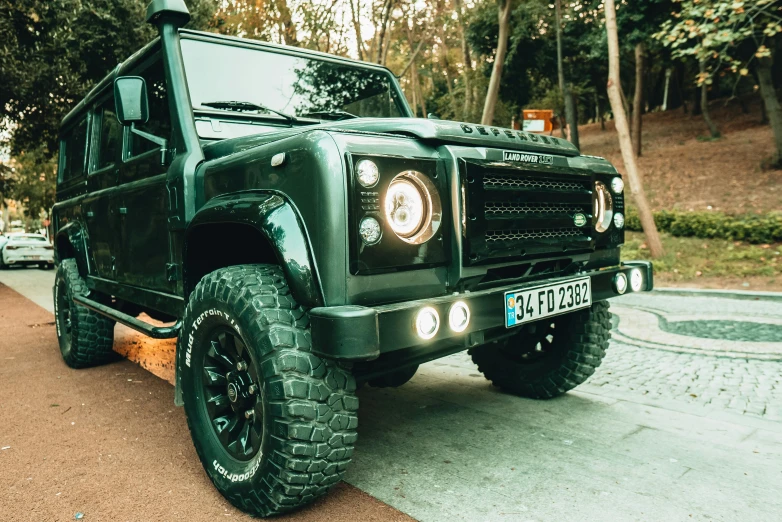 the new suv is parked in front of some trees