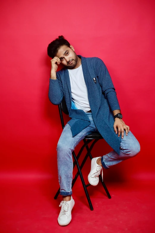 a man in a blue blazer sitting on a chair