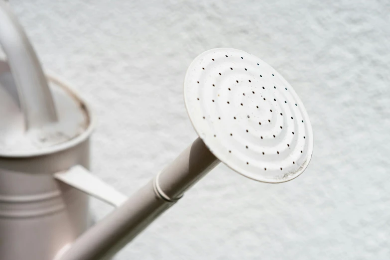 a white brush sits next to a metal cup on a surface