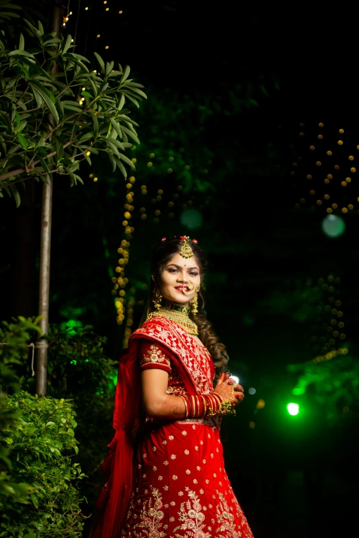 bride standing outside in traditional attire at night