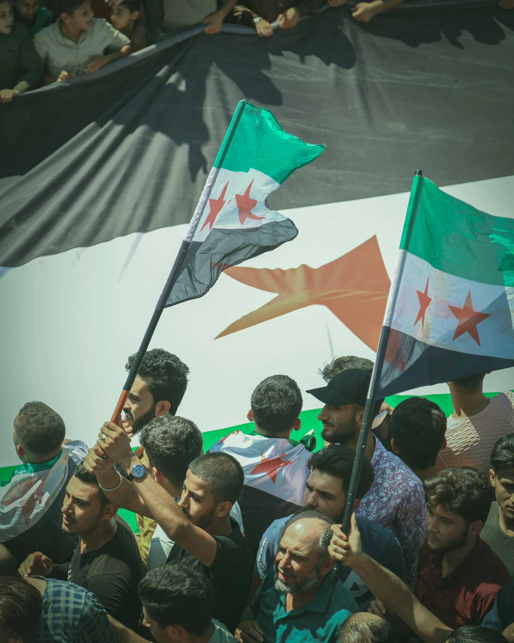 a crowd of people standing around a flag banner