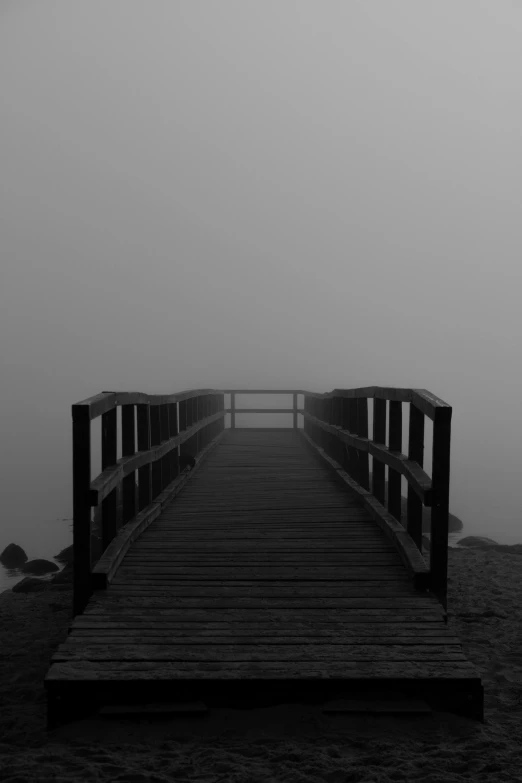 a dark boardwalk on a misty day