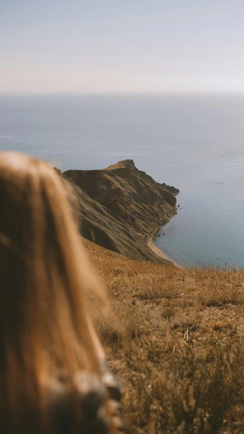 a beautiful woman is taking a picture of a cliff